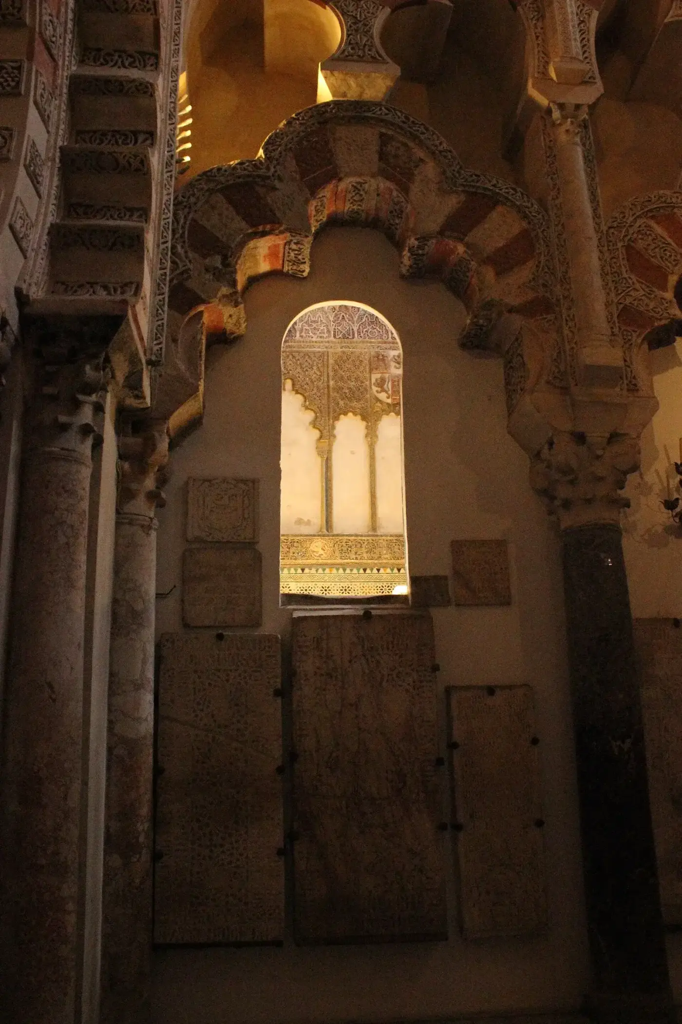 Bosque de columnas de la mezquita con dos niveles de arcos superpuestos; los arcos inferiores son de herradura y los superiores de medio punto, todos con dovelas alternas de piedra clara y ladrillo rojo.