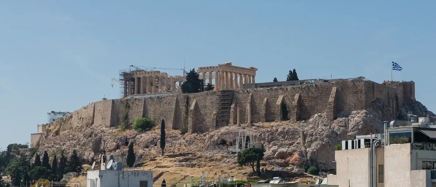 Fachada del templo dórico con columnas acanaladas, entablamento y frontón, sobre la plataforma escalonada de la Acrópolis.